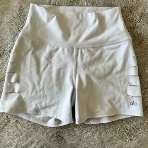 Alo Yoga high rise white shorts with slots on both sides.